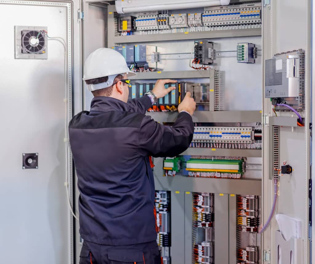 Technician working on wiring a control panel